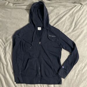 This is a Champion zip up sweater in the color navy blue. This is a size MEDIUM